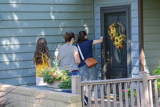 People knocking on doors to invite to people Harvest Baptist Church in Manhattan, KS